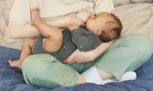 Une mère allaite son bébé. La question "mastite peut-on allaiter" est souvent posée, mais l'allaitement reste possible et bénéfique.