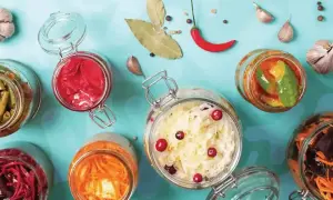 Bocaux de légumes fermentés, un aliment probiotique savoureux et coloré, avec ail, piment et feuilles de laurier.