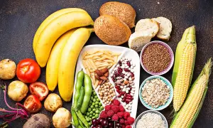 Bananes, pains, pâtes, maïs, riz, avoine, haricots, pois, baies et fruits : un assortiment coloré d'aliments riches en glucides.