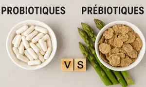 Probiotiques en gélules face à des asperges et des céréales, symbolisant le débat entre probiotique et prébiotique pour une flore intestinale saine.