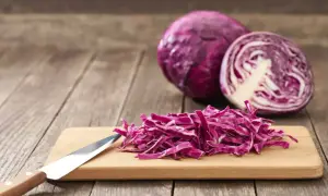 Chou rouge coupé en julienne sur une planche à découper, prêt à révéler ses nombreux chou rouge bienfaits.