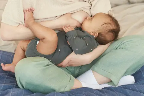 Une mère allaite son bébé. La question "mastite peut-on allaiter" est souvent posée, mais l'allaitement reste possible et bénéfique.