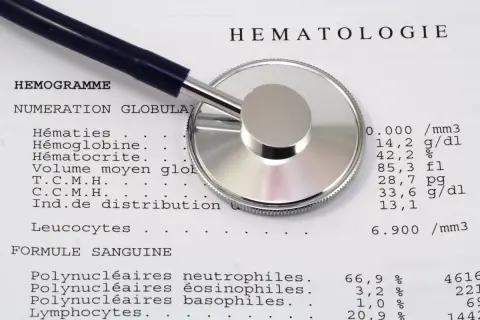 Un stéthoscope repose sur un compte rendu d'hématologie. Les résultats peuvent aider à évaluer la ferritine et l'inflammation.
