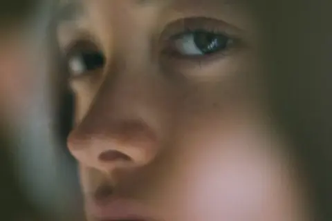 Gros plan sur le visage d'un enfant, l'œil est net, le reste est flou, évoquant une vision floue soudaine et la fatigue.