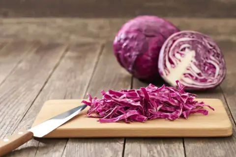 Chou rouge coupé en julienne sur une planche à découper, prêt à révéler ses nombreux chou rouge bienfaits.