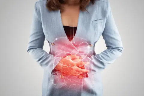 Femme tenant son ventre, avec une illustration du système digestif en rouge. Peut illustrer les symptômes de la candidose intestinale.