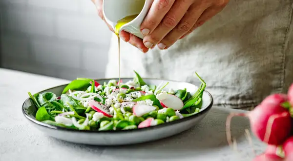 Salade fraîche avec vinaigrette versée, idéale pour nettoyer le foie et les reins naturellement. Épinards, radis, fèves et fromage frais.