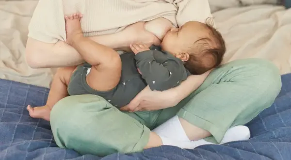 Une mère allaite son bébé. La question "mastite peut-on allaiter" est souvent posée, mais l'allaitement reste possible et bénéfique.