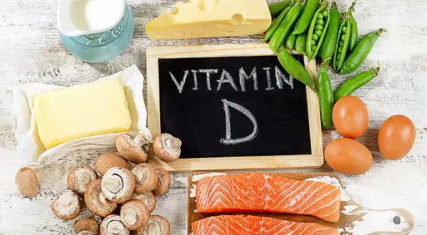 Assiette de vitamine D3 aliments : saumon, œufs, champignons, fromage, pois, beurre et lait.
