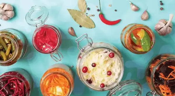 Bocaux de légumes fermentés, un aliment probiotique savoureux et coloré, avec ail, piment et feuilles de laurier.