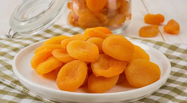 Assiette de fruits secs orangés, des abricots qui, consommés en excès, peuvent causer une légère diarrhée.