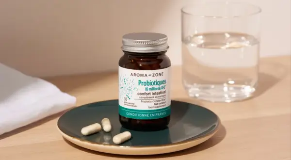 Bouteille de probiotiques Aroma-Zone sur une assiette, avec des gélules et un verre d'eau. Idéal pour savoir quand faire une cure de probiotiques.