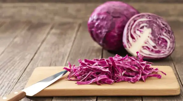 Chou rouge coupé en julienne sur une planche à découper, prêt à révéler ses nombreux chou rouge bienfaits.