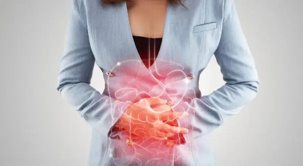 Femme tenant son ventre, avec une illustration du système digestif en rouge. Peut illustrer les symptômes de la candidose intestinale.