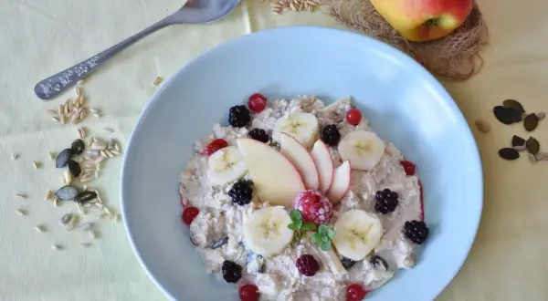 Un bol de flocons d'avoine garni de fruits frais et de graines, un petit-déjeuner sain pour profiter des flocons d'avoine bienfaits.
