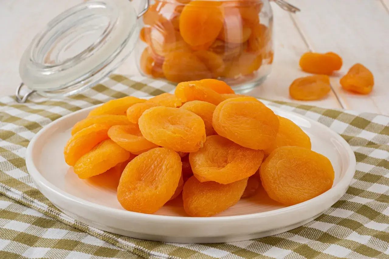 Assiette de fruits secs orangés, des abricots qui, consommés en excès, peuvent causer une légère diarrhée.