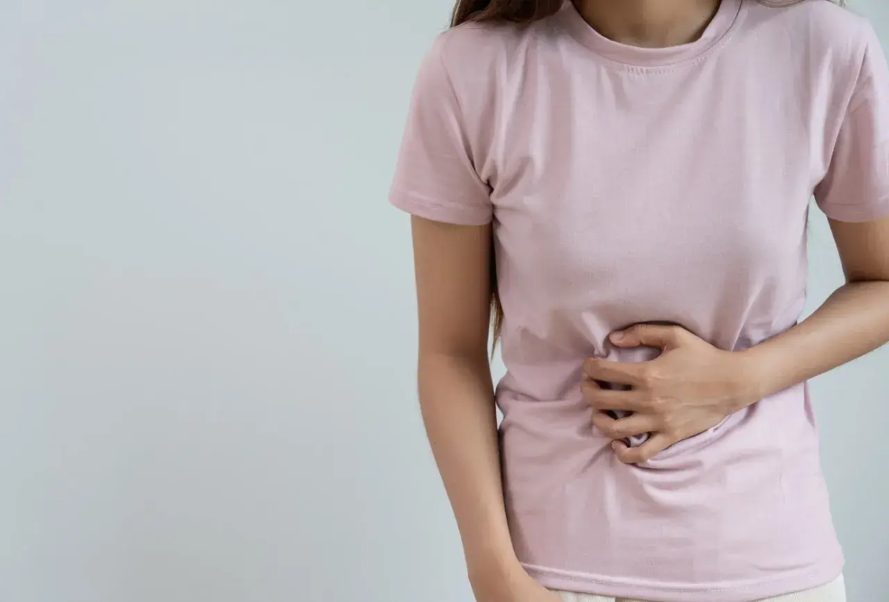 Femme tenant son ventre, souffrant de digestion difficile. Peut-être un remède grand-mère serait utile ?
