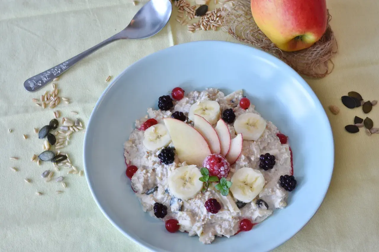Un bol de flocons d'avoine garni de fruits frais et de graines, un petit-déjeuner sain pour profiter des flocons d'avoine bienfaits.