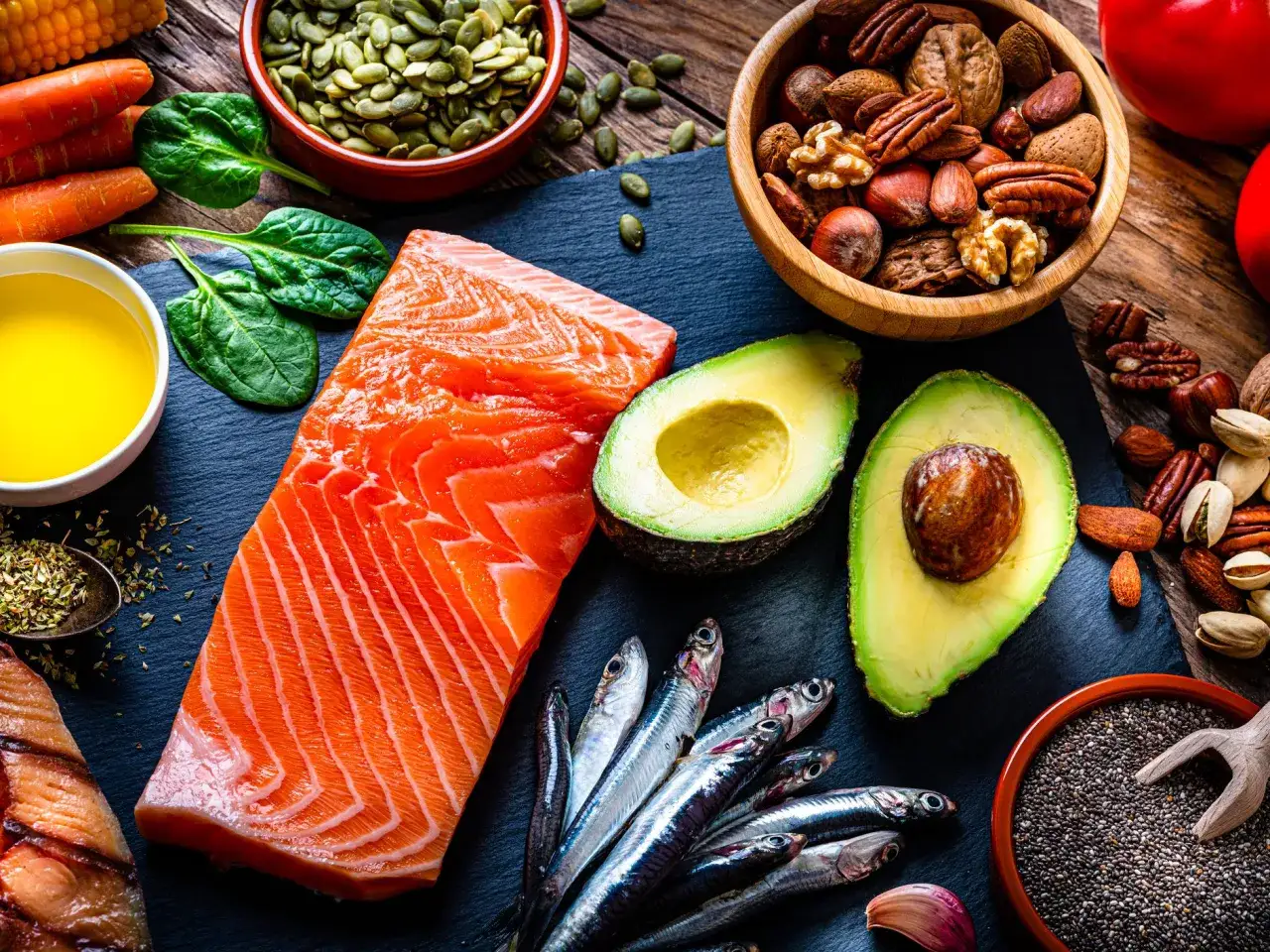 Saumon, avocat, sardines, noix et graines de chia, riches en acide gras polyinsaturé, pour un repas sain.