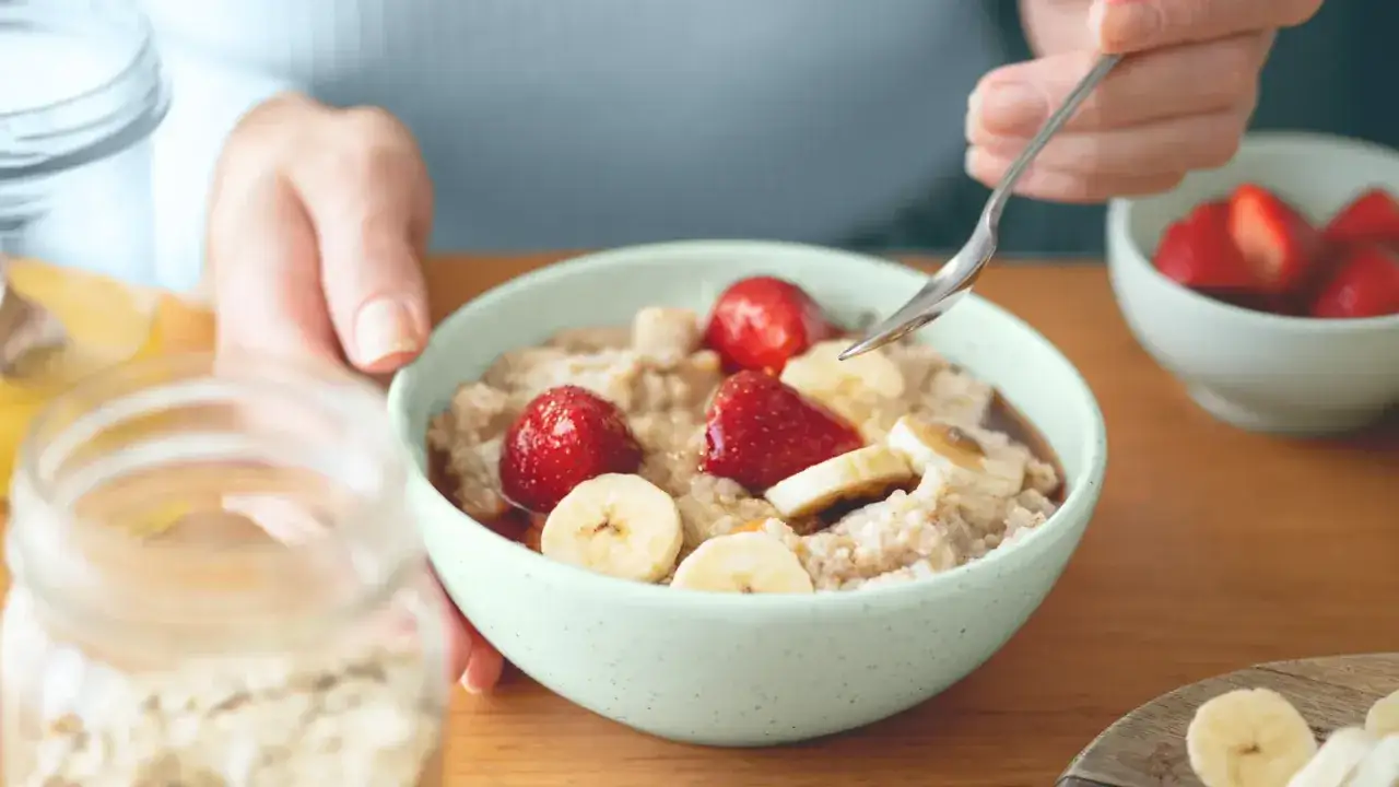 Un bol de flocon d'avoine avec des fraises et des bananes, un petit-déjeuner doux pour l'intestin irritable.
