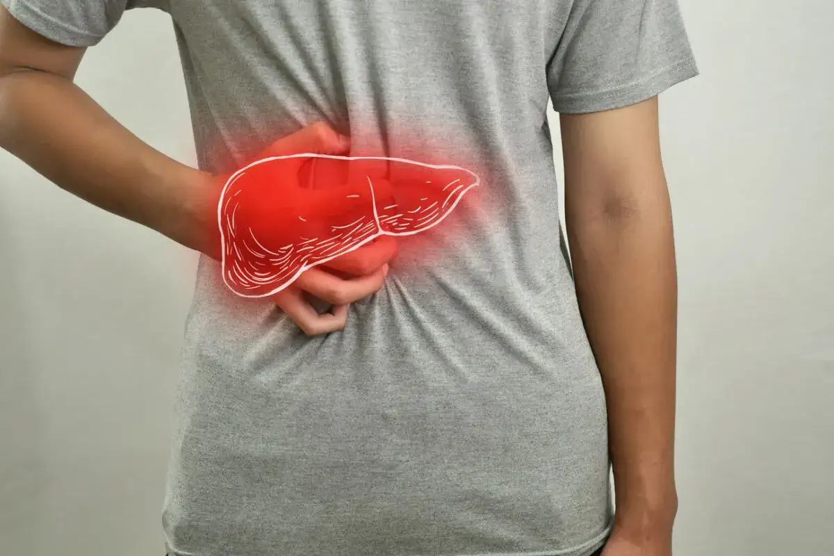 Une main serre le flanc, là où se trouve le foie, symbolisé par une illustration rouge et lumineuse.