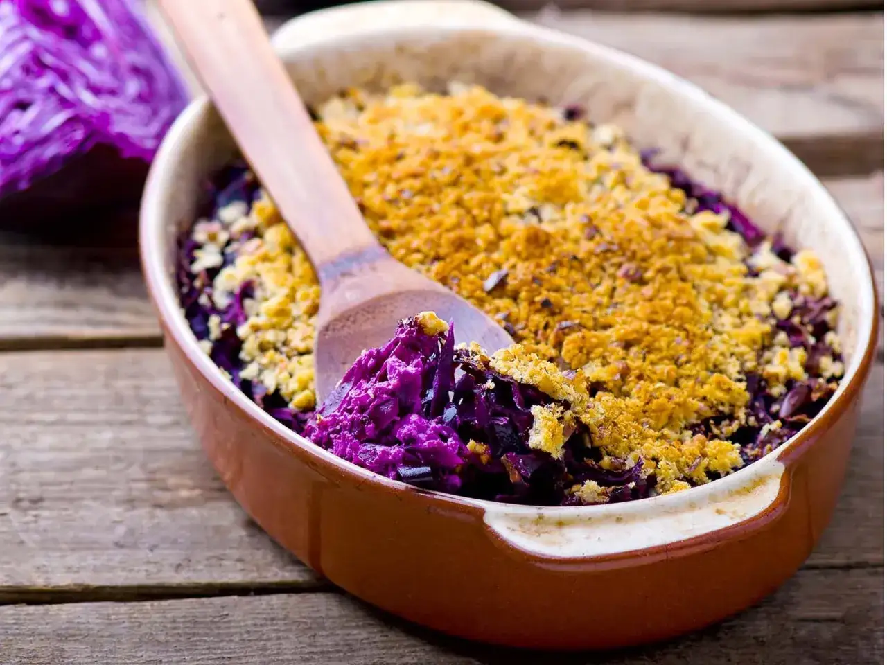 Un gratin de chou rouge, savoureux et color&eacute;, pour profiter des chou rouge bienfaits. Une cuill&egrave;re en bois sert le plat.