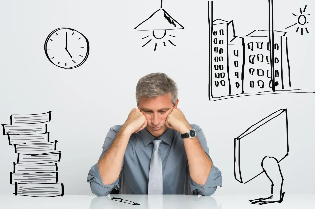 Un homme d'affaires, accablé par la grosse fatigue, s'affale sur son bureau. Autour de lui, des dessins : une pile de livres, une horloge, une lampe, un ordinateur et des immeubles.