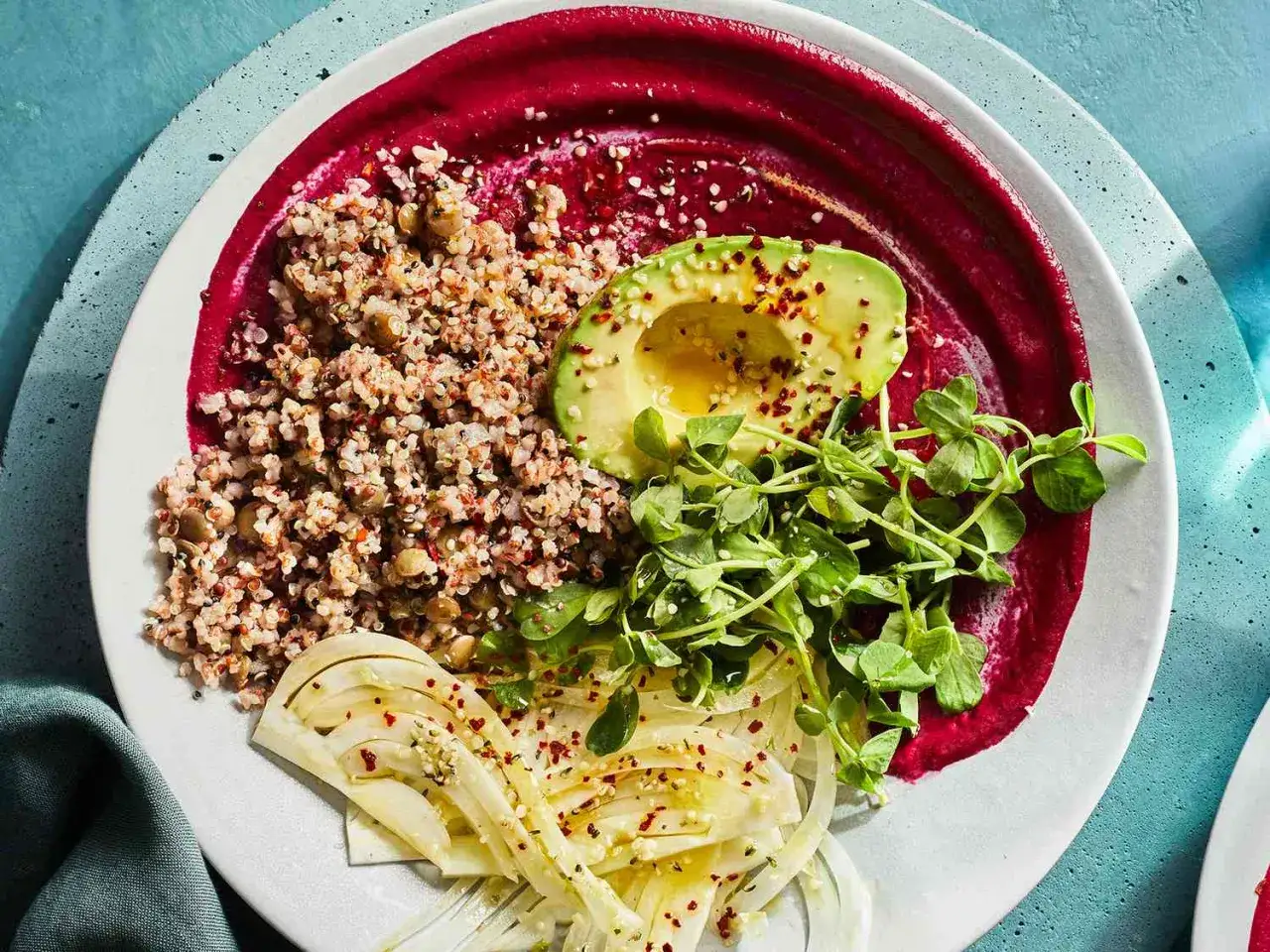 Un bol coloré avec purée de betterave, quinoa, avocat, fenouil et pousses. Idéal pour les aliments à manger pour restaurer la flore intestinale.