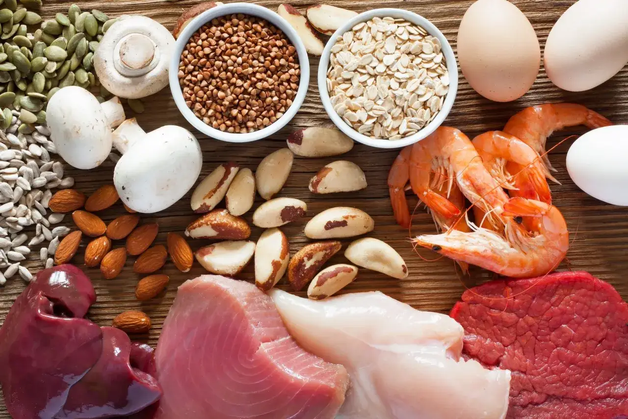 Assortiment d'aliments riches en sélénium : foie, thon, crevettes, œufs, champignons, noix du Brésil, amandes, graines de tournesol et de citrouille, flocons d'avoine et sarrasin.