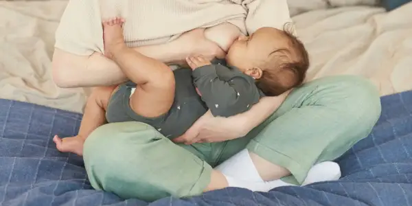 Une mère allaite son bébé. La question "mastite peut-on allaiter" est souvent posée, mais l'allaitement reste possible et bénéfique.