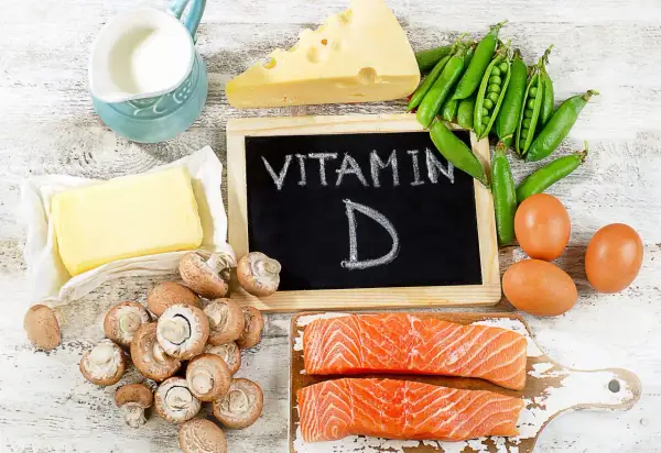 Assiette de vitamine D3 aliments : saumon, œufs, champignons, fromage, pois, beurre et lait.