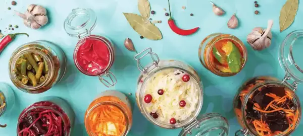 Bocaux de légumes fermentés, un aliment probiotique savoureux et coloré, avec ail, piment et feuilles de laurier.