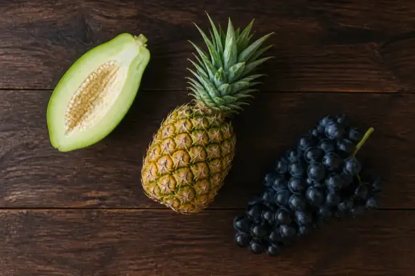 Papaye verte coupée, ananas et raisins noirs. Attention, ce sont les 3 fruits à éviter pendant la grossesse.